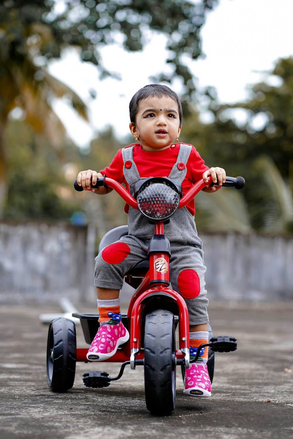 Niño con camisa roja montando bicicleta roja durante el día