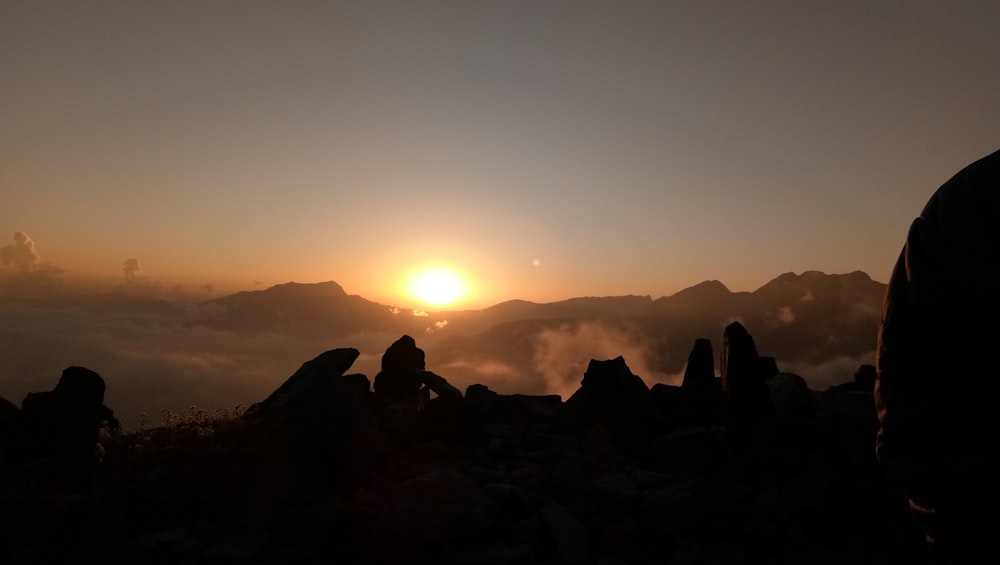 silhouette of people on mountain during sunset