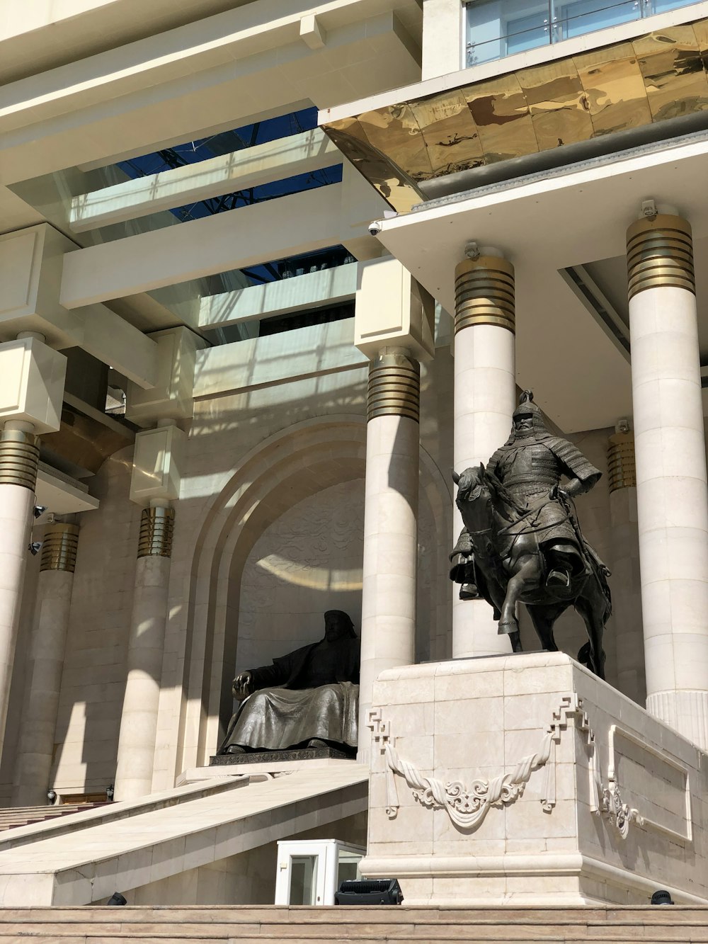 Hombre con chaqueta negra y pantalones de pie junto a la estatua del hombre