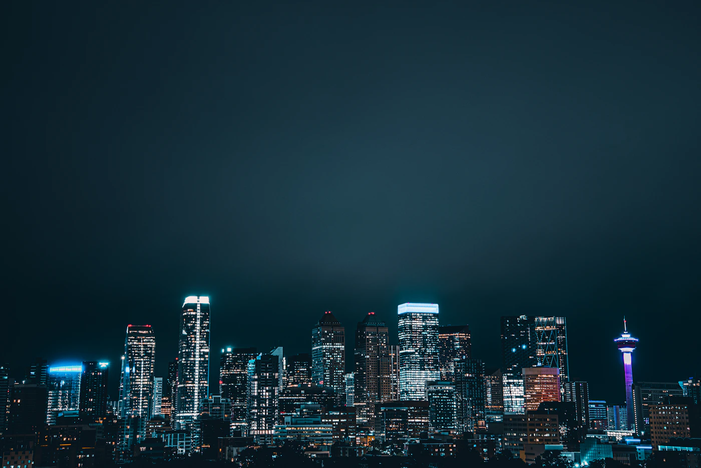 The downtown Calgary skyline of lit office towers across the Alberta city at dusk