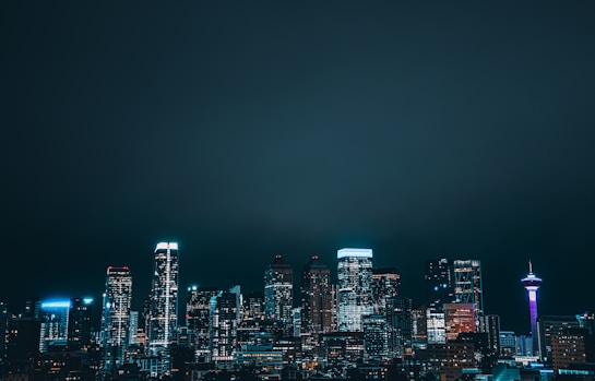 a city skyline at night with the lights on