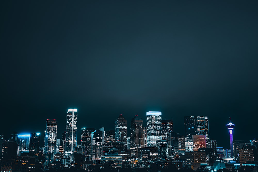 a city skyline at night with the lights on