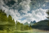 An artistic reflection of a serene landscape with trees and a cloudy sky mirrored on water, creating an ethereal and abstract scene.
