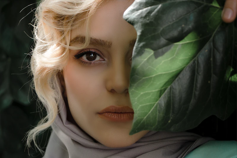 modest woman in white hijab framed by green leaves