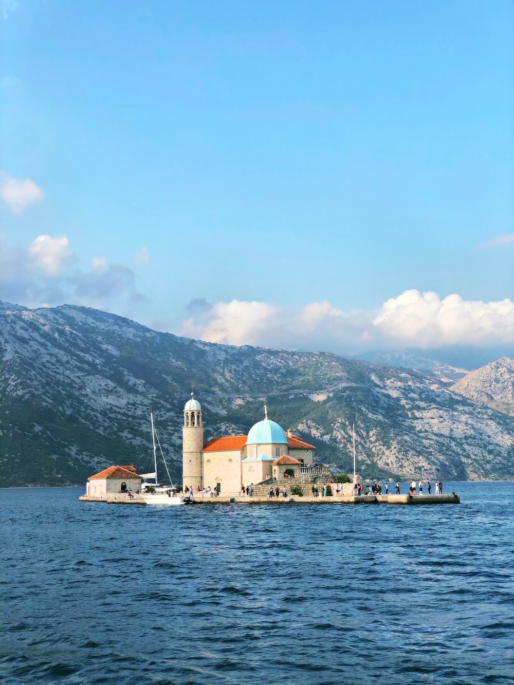 white and brown concrete building near body of water during daytime