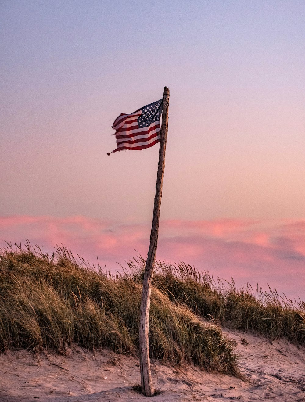 us a flag on brown grass field during sunset