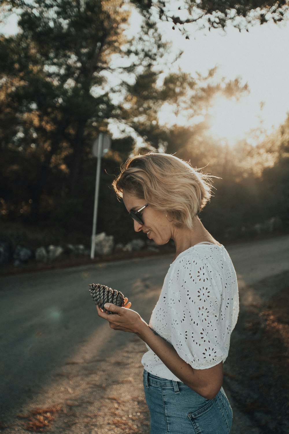 woman in white and black floral shirt holding black and white bird
