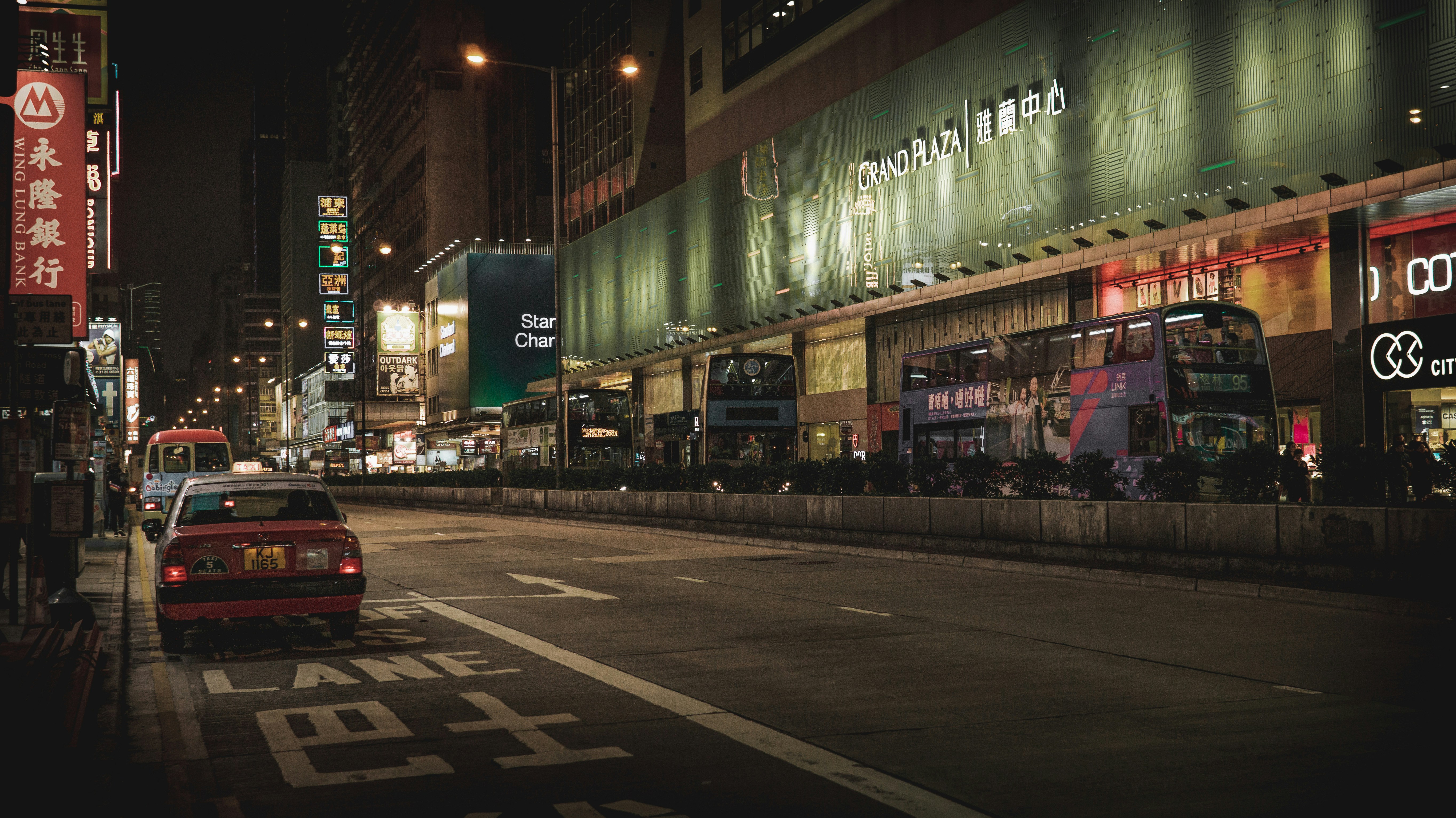 red car parked beside the building during night time