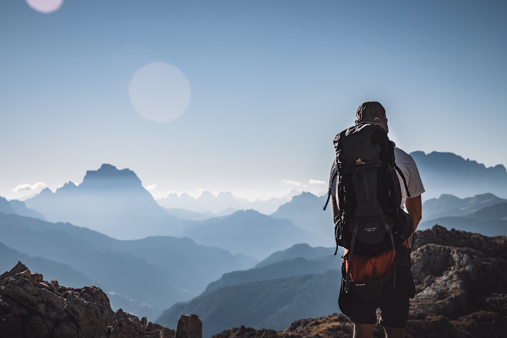 man in black jacket and black backpack standing on rock formation during daytime