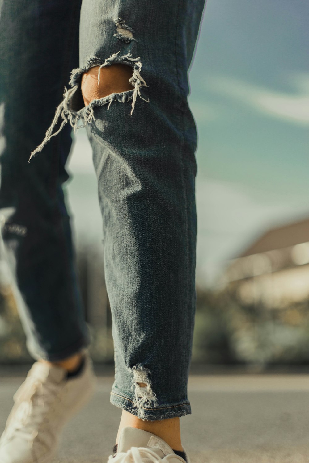 person in blue denim jeans and brown leather boots