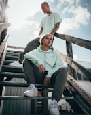 woman in green hoodie sitting on brown wooden bench