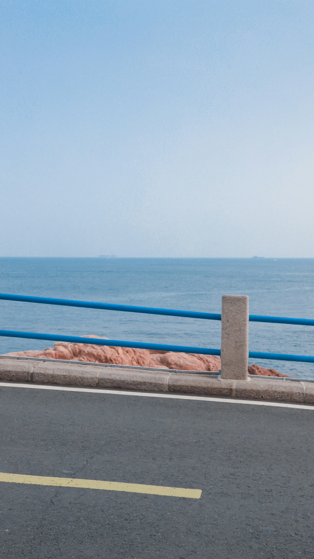 낮 동안 푸른 바다 근처의 갈색 콘크리트 벽