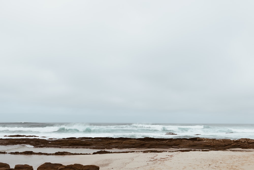 ocean waves crashing on shore during daytime