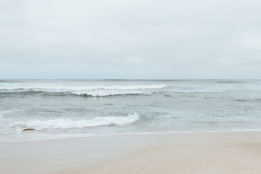 ocean waves crashing on shore during daytime