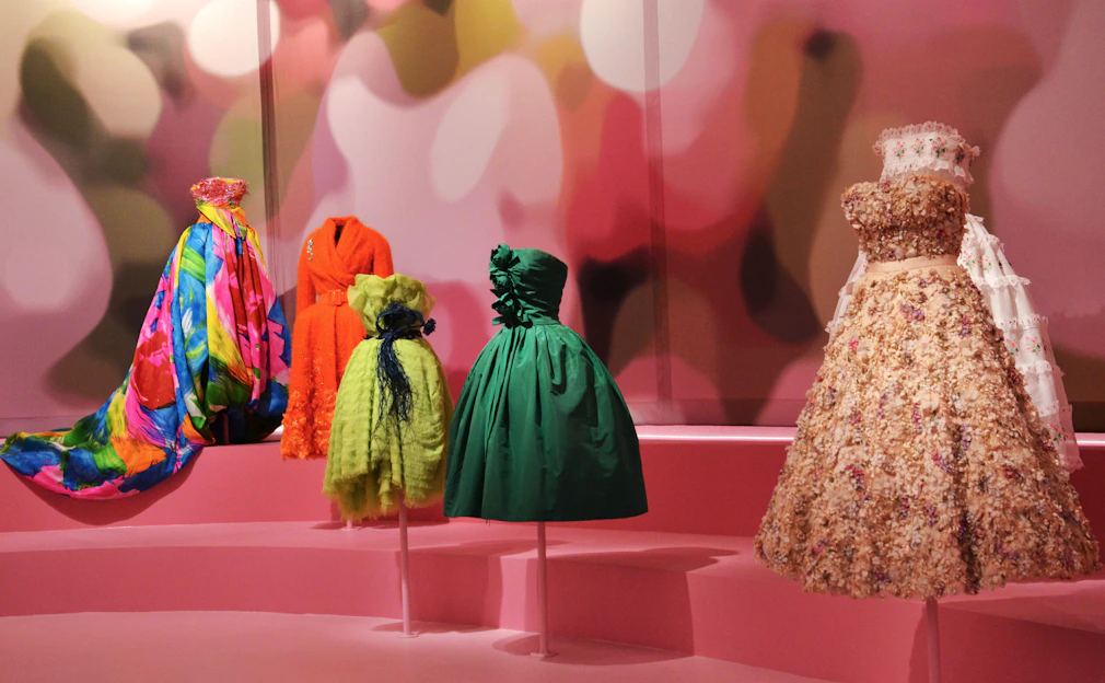 A bright and colorful display of quinceañera and toddler dresses arranged elegantly with matching accessories.