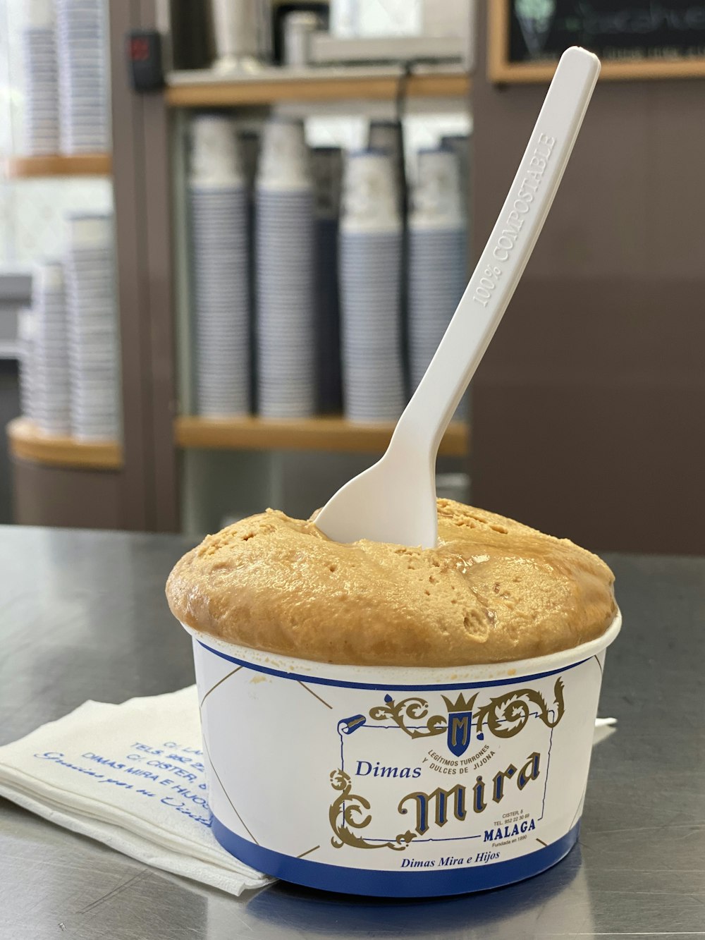 white and blue ceramic mug with stainless steel spoon