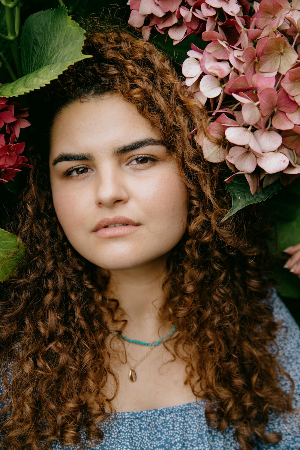 woman in blue and white floral shirt with brown hair