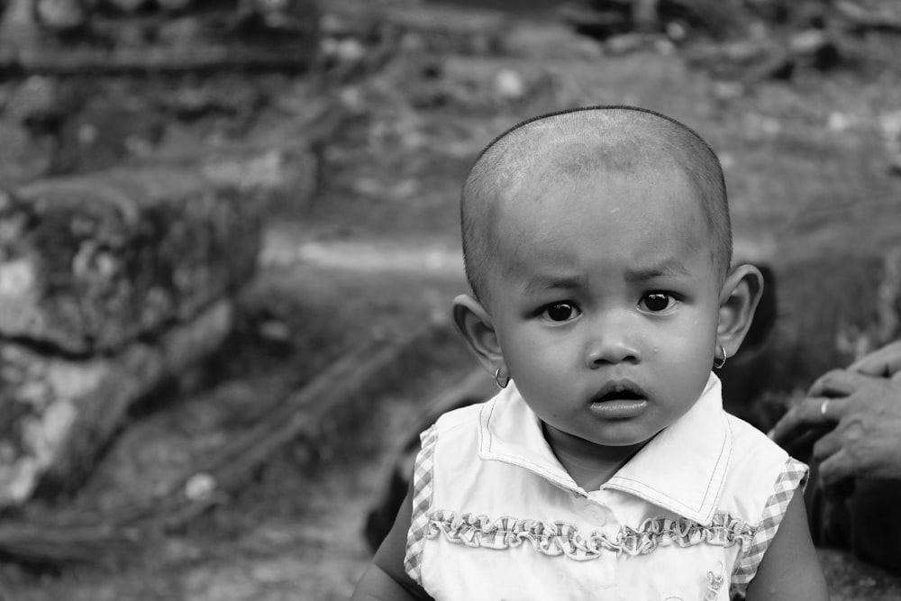 grayscale photo of baby in white collared shirt