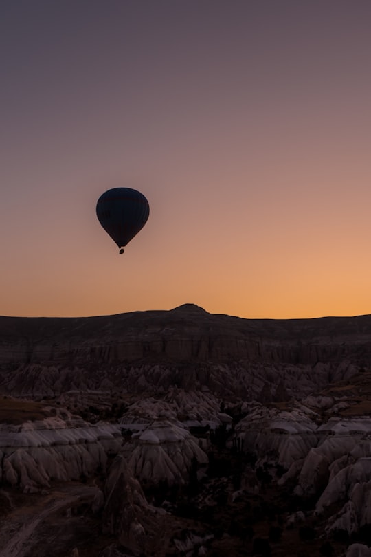hot air balloon flying over the city during sunset in Cappadocia Turkey