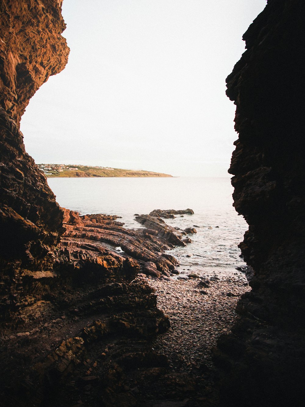 brown rock formation near body of water during daytime