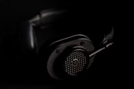 Microphone and headphones set against a textured black background with urban vibe