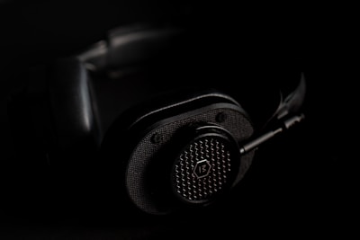 Close-up of sleek headphones with subtle green accent lighting on a black background