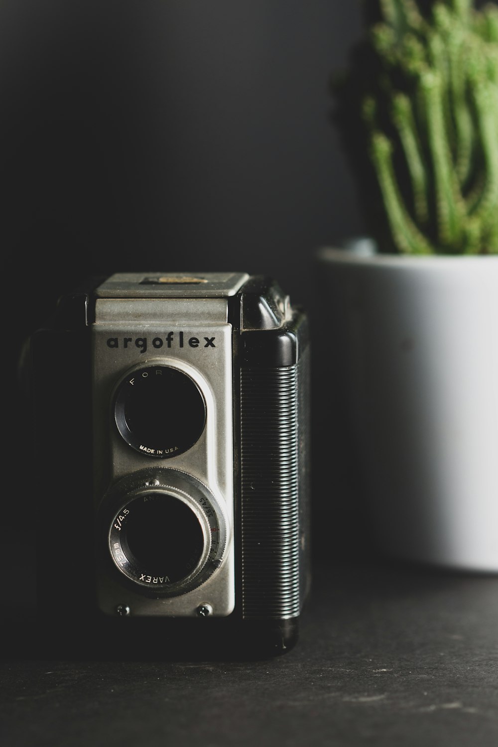 black and silver camera beside white ceramic mug