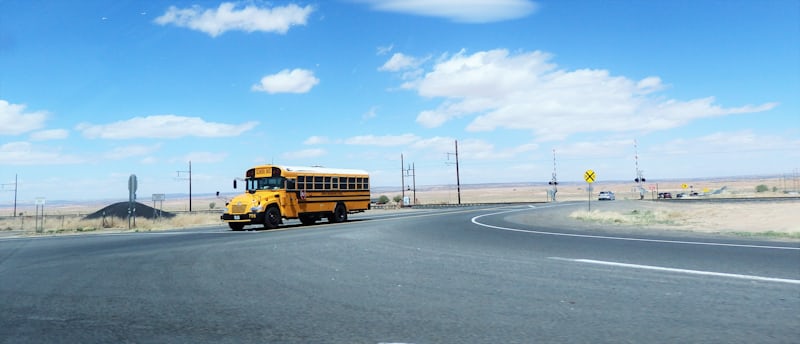 A yellow school bus on a road during the morning commute in a Las Vegas neighborhood