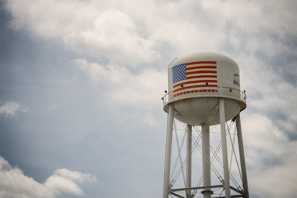 red and white water tank under white clouds