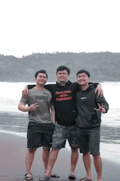 Men walking together along a stormy coastline, embodying brotherhood.