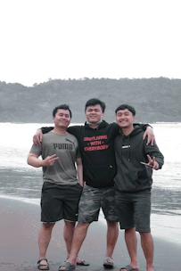 Men walking together along a stormy coastline, embodying brotherhood.