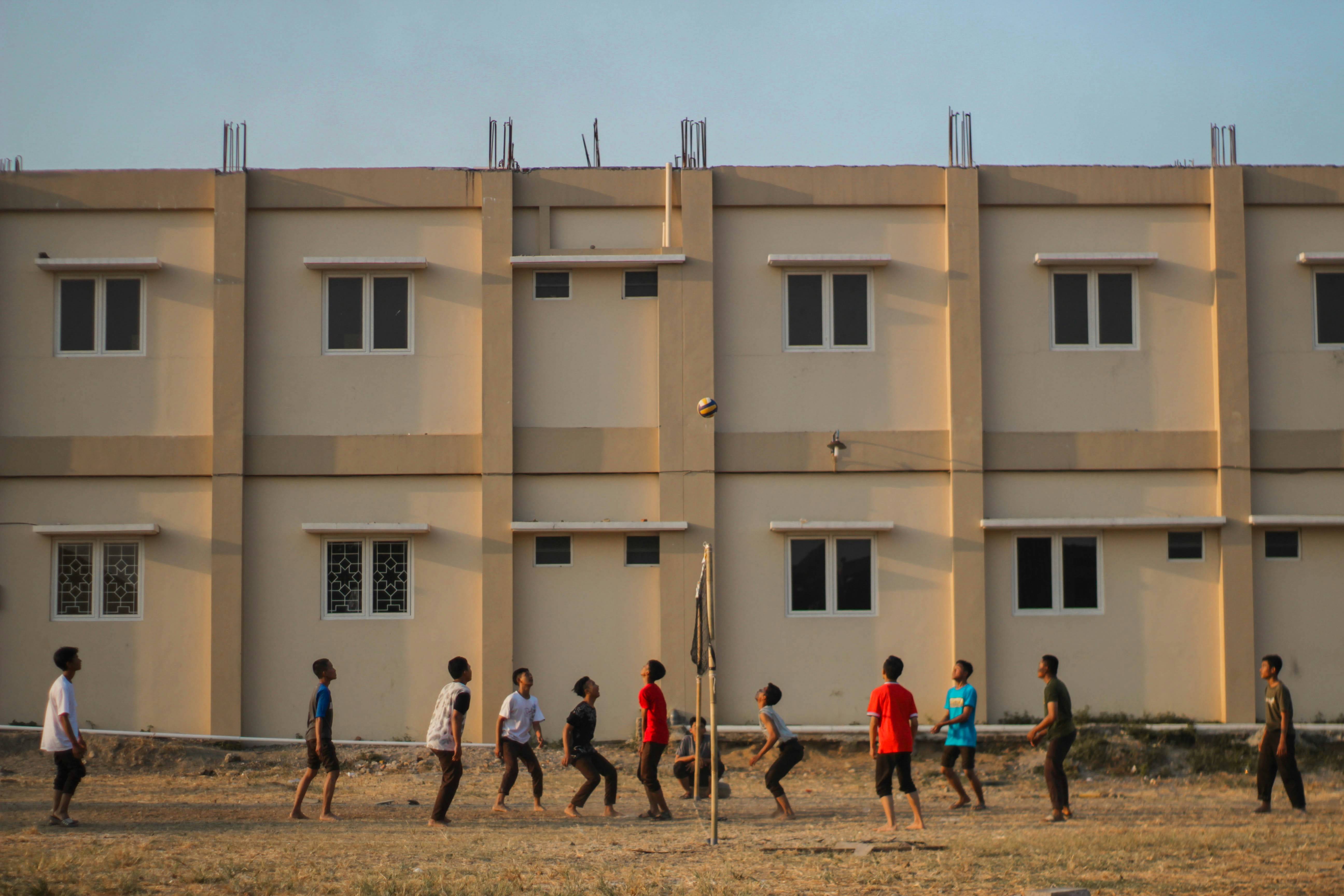 Les gens marchent devant un bâtiment en béton beige pendant la journée