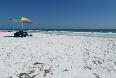 Friendly team member helping a customer choose a beach umbrella on a sunny Oak Island day.