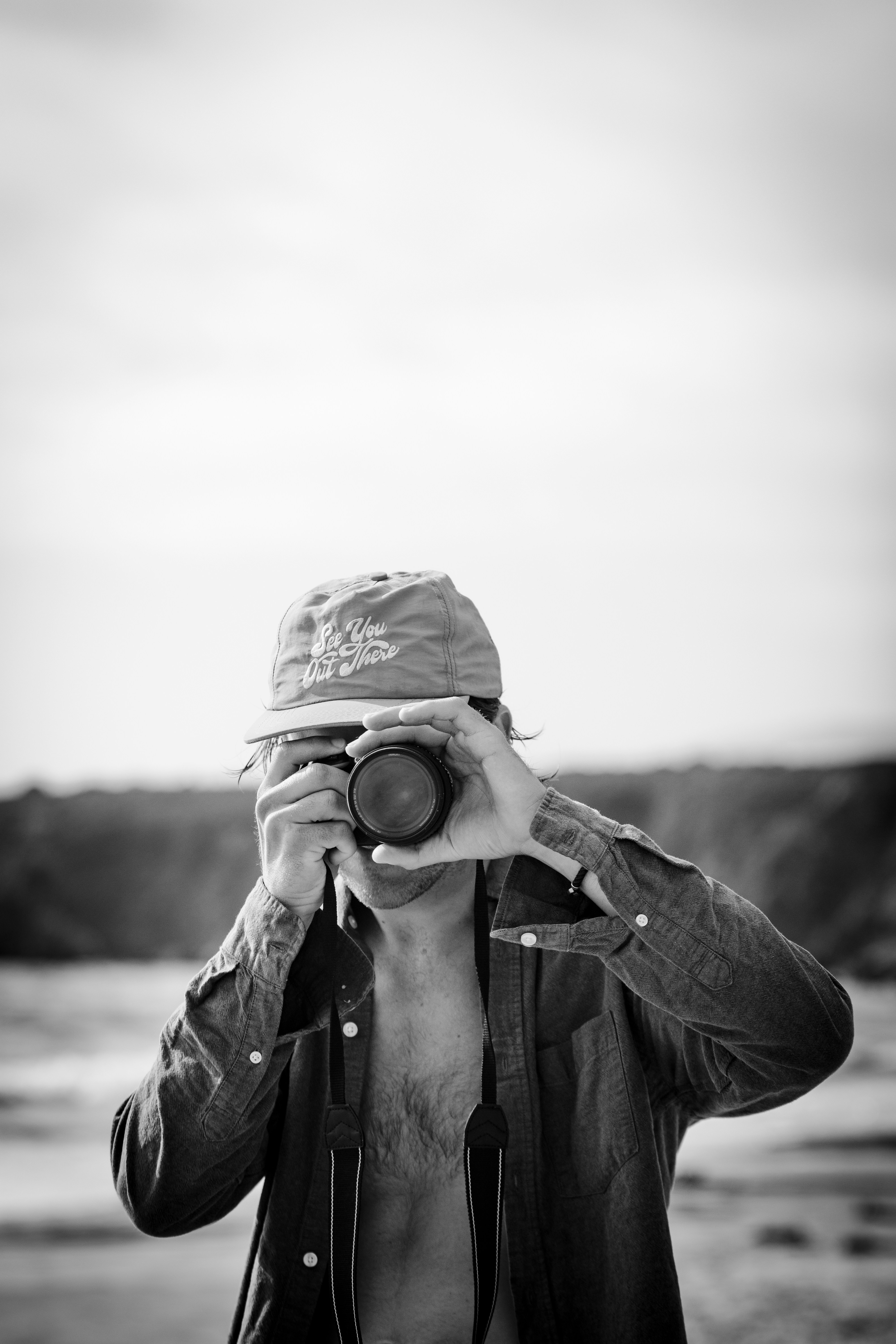 man taking photo black and white on beach