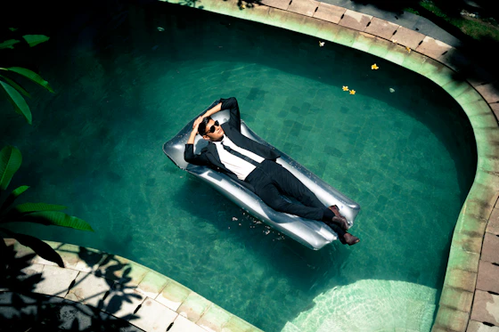 woman in black and white dress lying on pool side during daytime