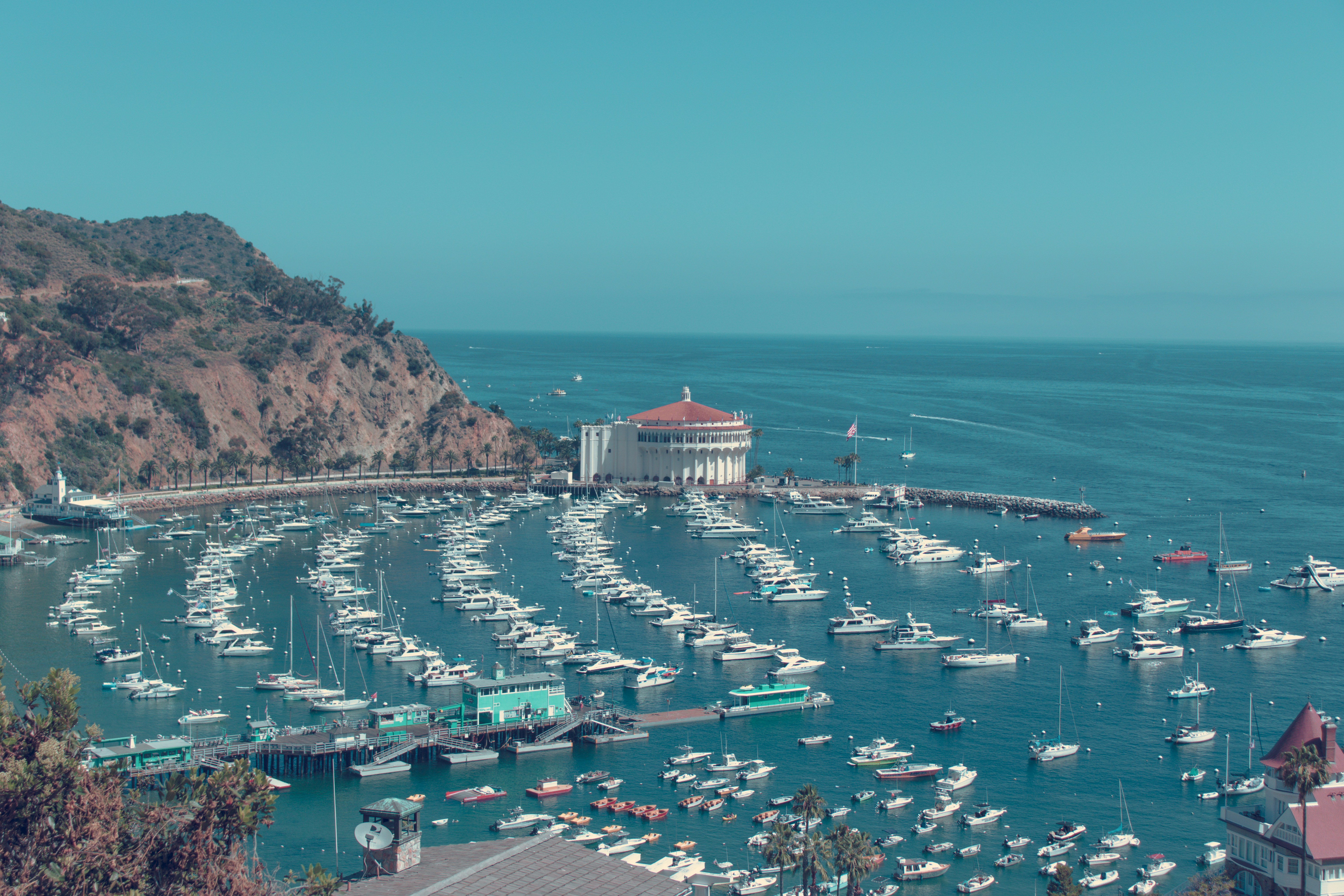 aerial view of boats on sea near mountain during daytime