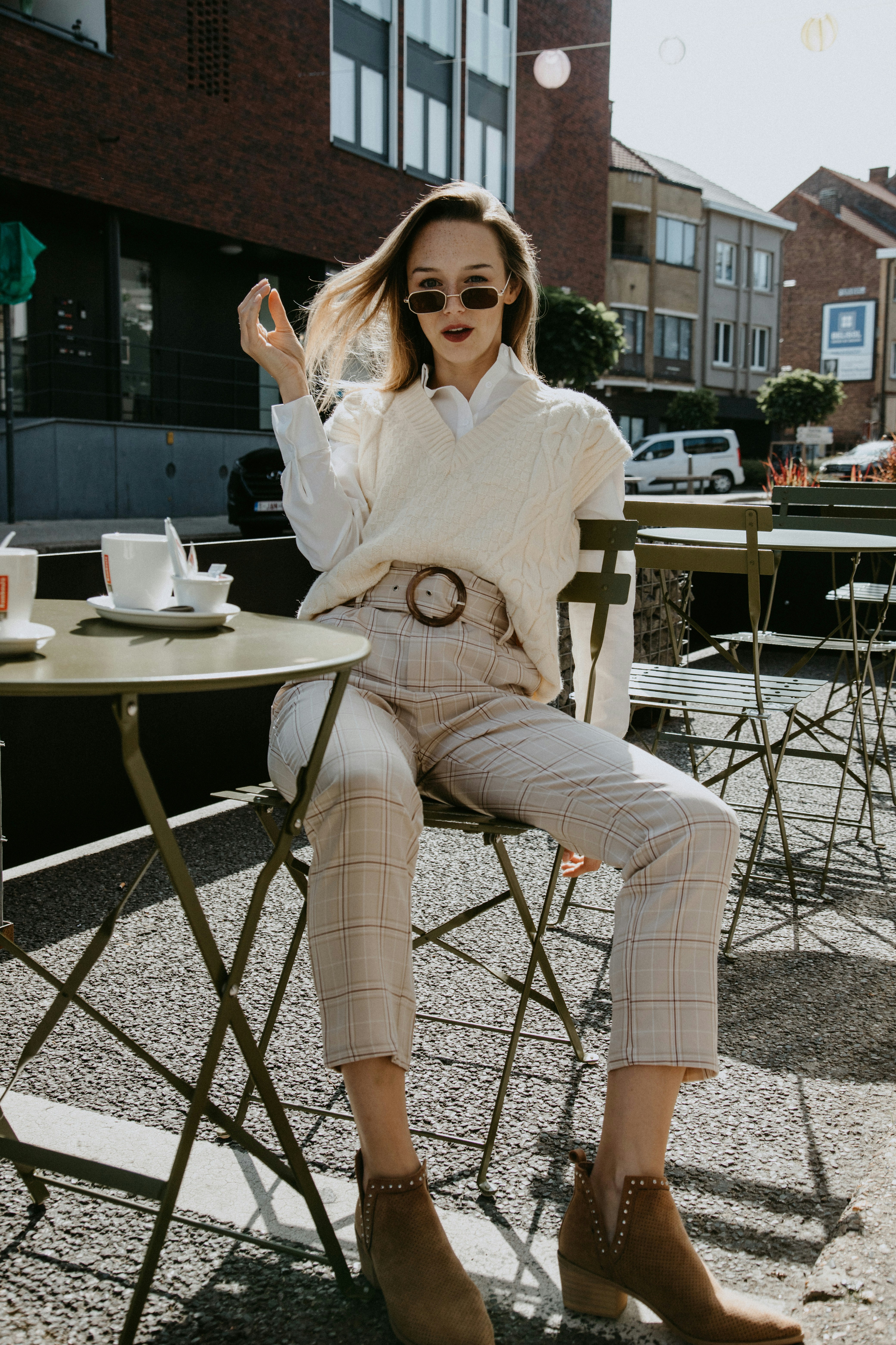 Woman in white long sleeve shirt and brown pants sitting on chair photo ...