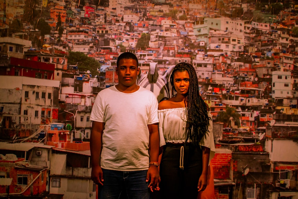 man in white crew neck t-shirt standing beside woman in black pants