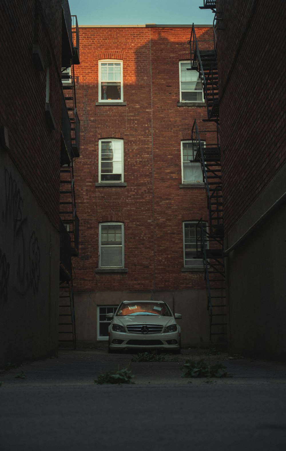 silver car parked beside brown brick building
