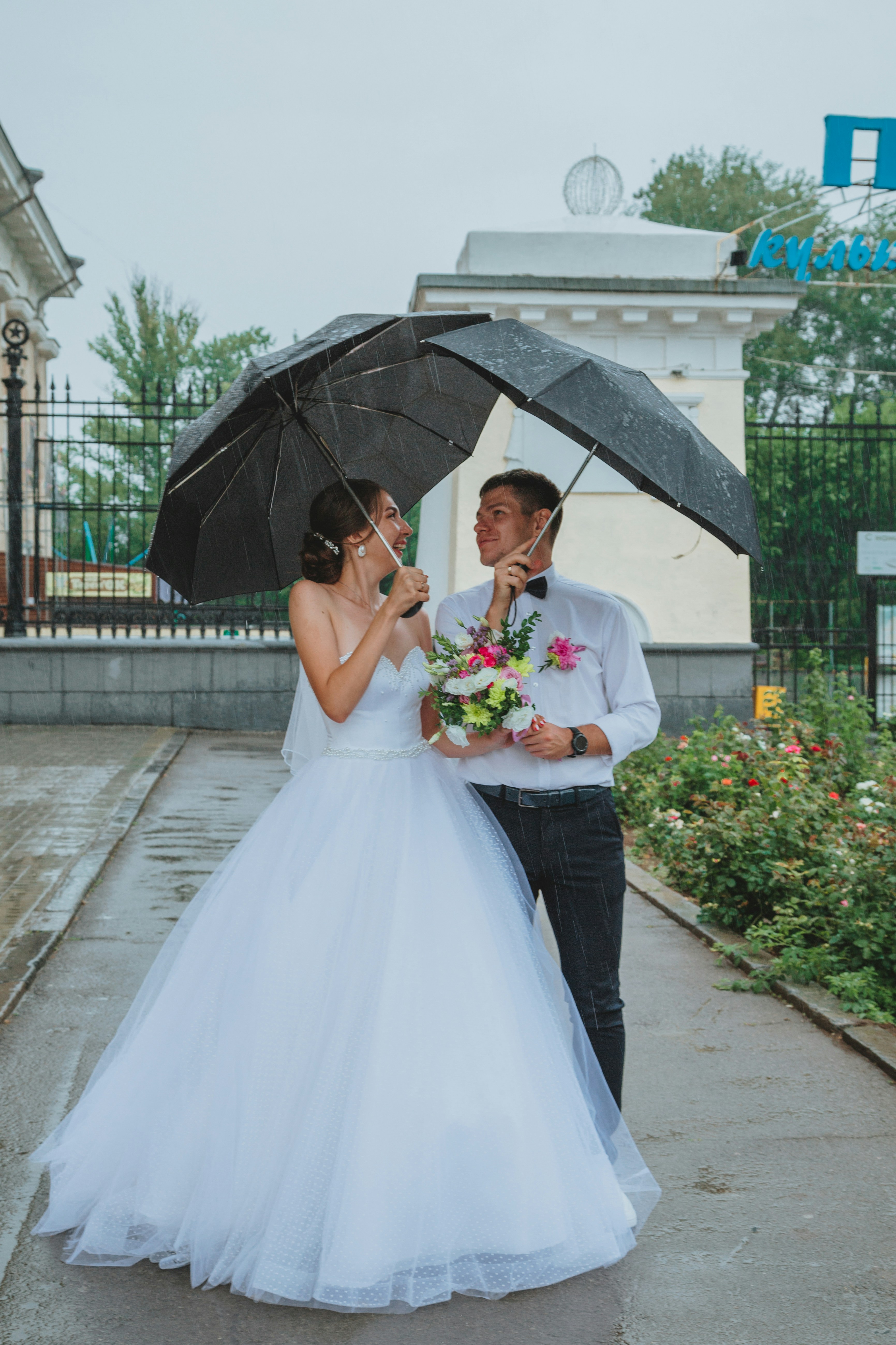woman in white wedding gown holding umbrella