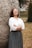 woman in white long sleeve shirt and black skirt standing beside brown tree during daytime