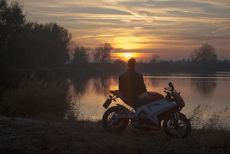 man riding motorcycle on river during sunset