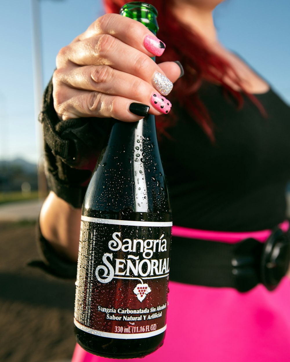 person holding black and red bottle