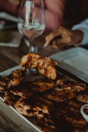 A happy customer enjoying a meal at Royal Chicken and Grill LLC, smiling with a forkful of food.