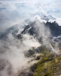 Misty clouds swirling around the towering cliffs of the Prokletije at dawn.