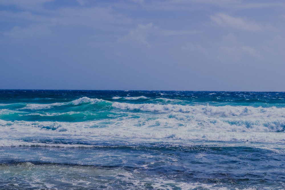 ocean waves under cloudy sky during daytime