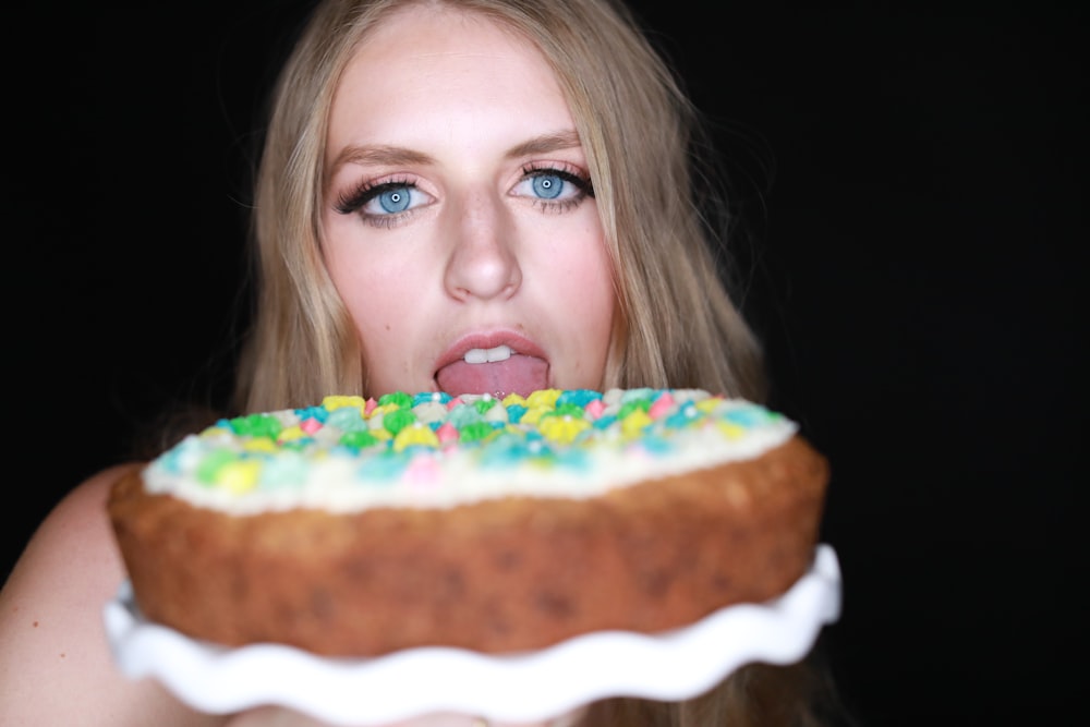 girl with blonde hair holding a pizza