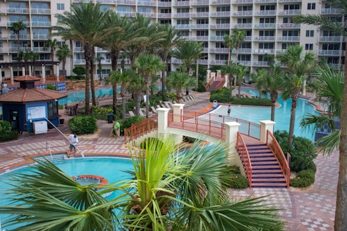 swimming pool near palm trees and building during daytime