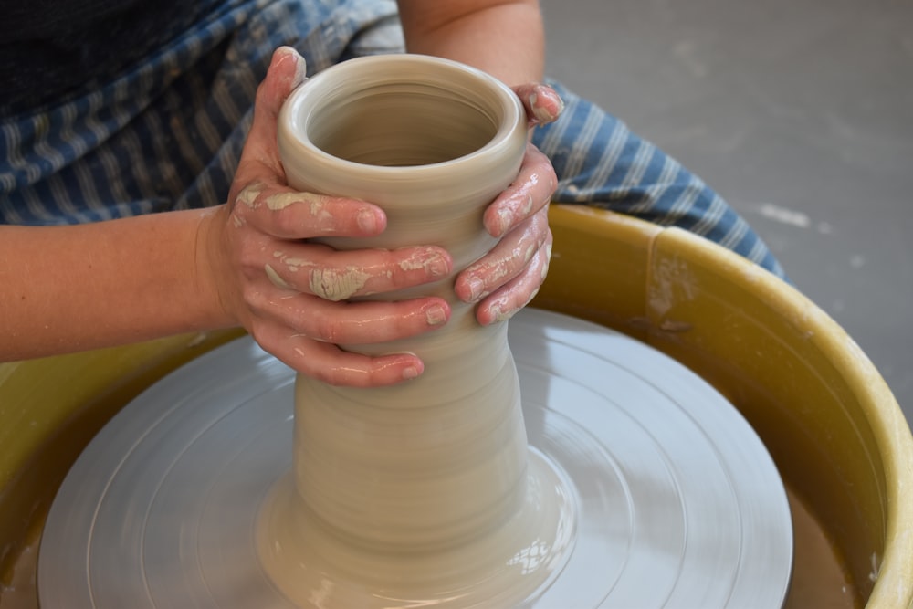 white clay pot on white round plastic container