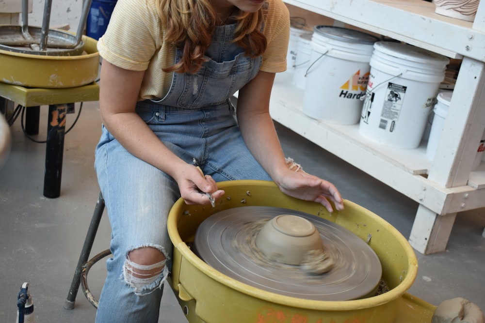 person in gray t-shirt holding round white plastic container